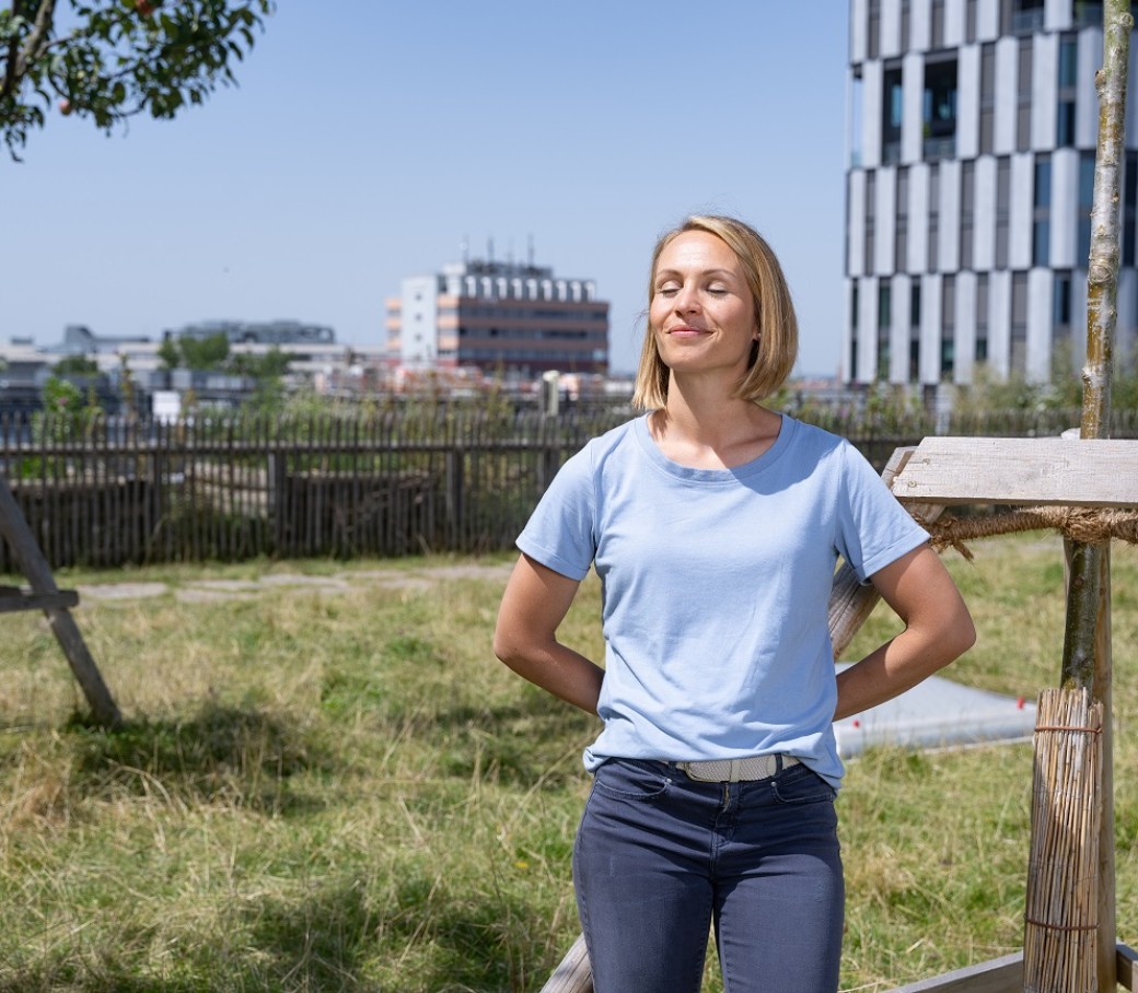 Magdalena Neuner steht auf einem Almdach in München und genießt mit geschlossenen Augen die Sonne.