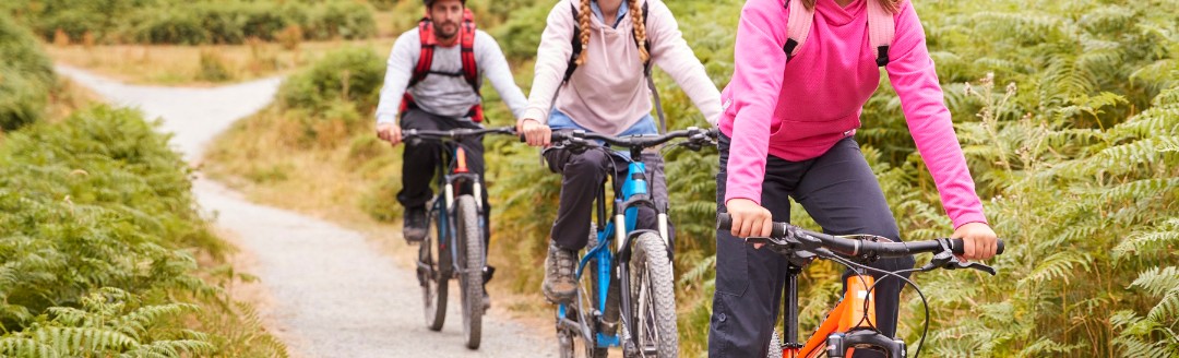 Mädchen fährt Mountain-Bike mit ihren Eltern