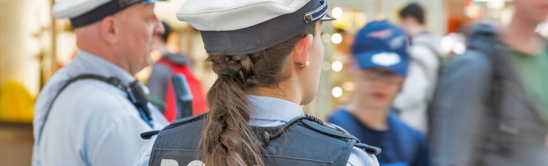 Ein Polizeibeamter und eine jüngere Polizistin im Einsatz in einem Shopping-Center