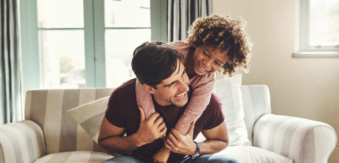 Vater und Kind tollen zuhause auf dem Sofa