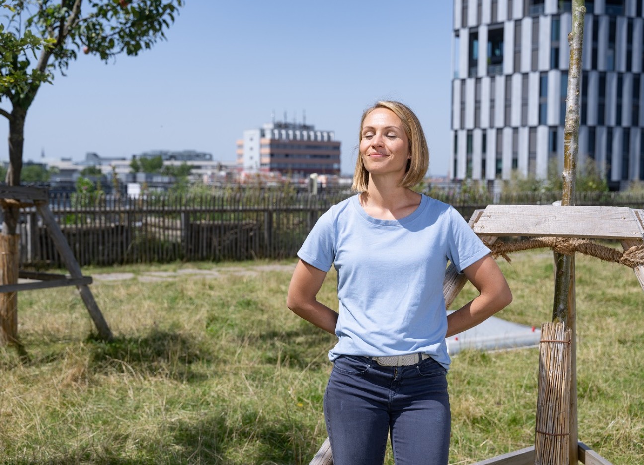 Magdalena Neuner steht auf einem Almdach in München und genießt mit geschlossenen Augen die Sonne.