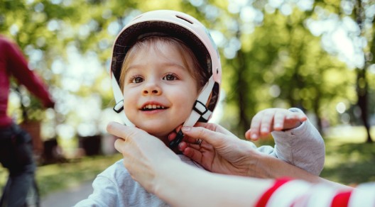 Ein Kind bekommt einen Helm aufgesetzt