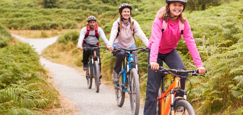 Mädchen fährt Mountain-Bike mit ihren Eltern