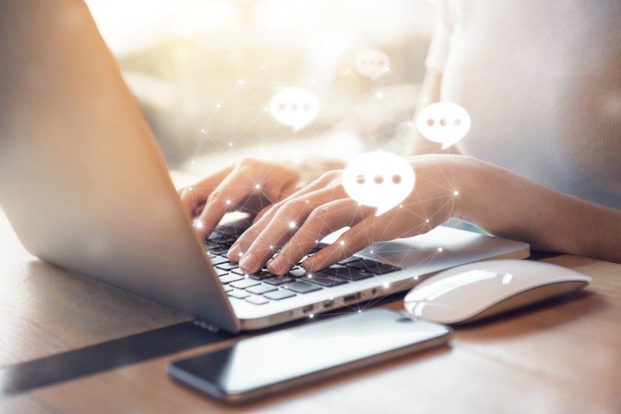 Ein Mann sitzt vor seinem Laptop, auf dem er die Website der Bayerischen geöffnet hat, und verwendet gleichzeitig sein Handy Ein Mann sitzt vor seinem Laptop, auf dem er die Website der Bayerischen geöffnet hat, und verwendet gleichzeitig sein Handy