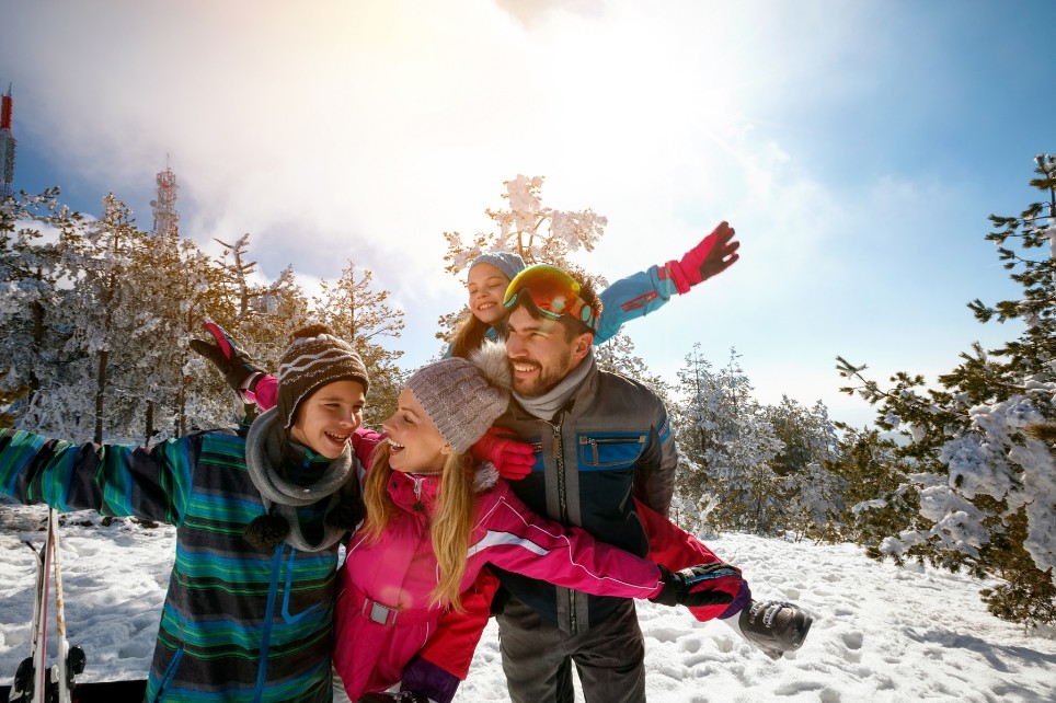 Familie genießt Winterurlaub in den Bergen und macht Selfie