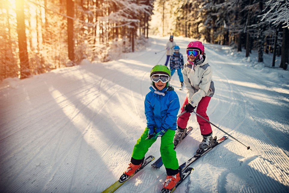 Familie hat Spaß beim Skifahren gemeinsam am Wintertag